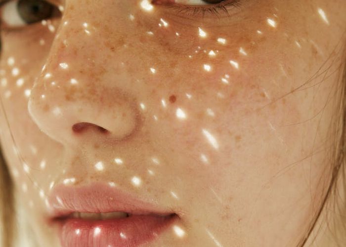 Person stretching gently outdoors with a calm expression on their face.